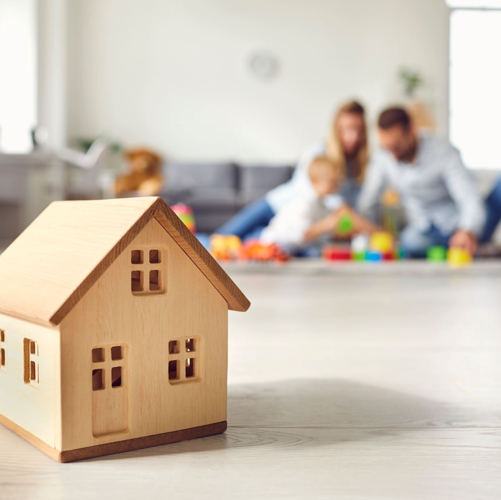Family sits together behine a home icon